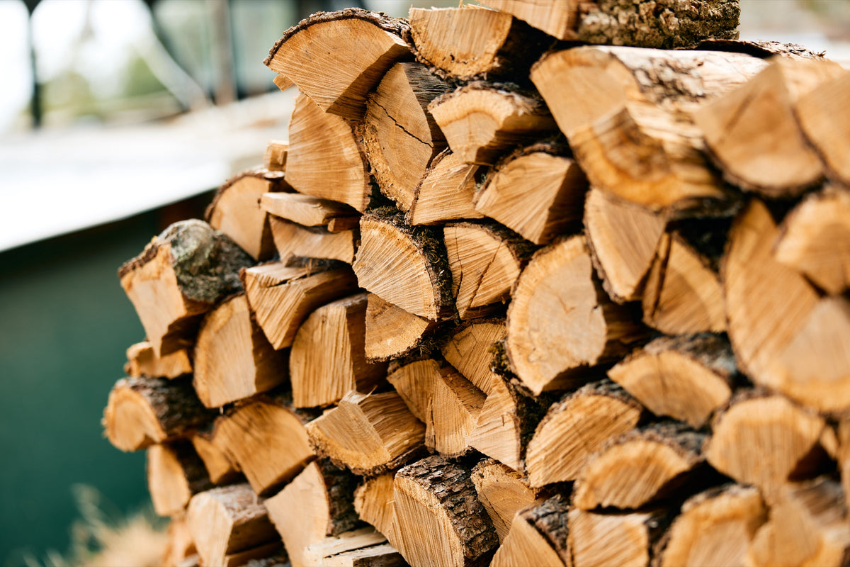 Stacked split hardwood firewood — reliable commercial-volume supply